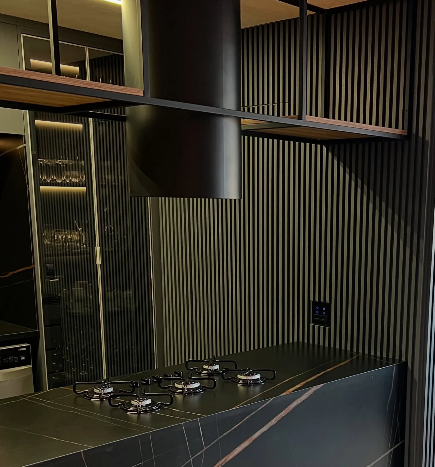 Detalhe de cooktop em ilha dark com ripado · móveis planejados TAVIPLAN